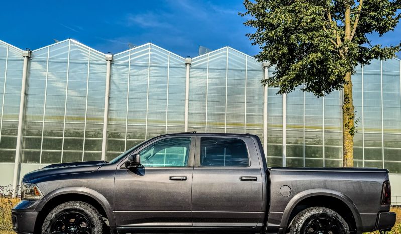 DODGE RAM 1500 5.7L HEMI V8 4X4 401PK * LARAMIE * BLACK-OPPS * 1E EIGENAAR * CUSTOM PERFORMANCE HOOD * AFSTAND START * 122 LITER PRINS LPG * 3500 KG TREKGEWICHT TREKHAAK * SMOKE VERLICHTING ROND OM * STOELVERKOELING * STOELVERWARMING * STUURVERWARMING * vol